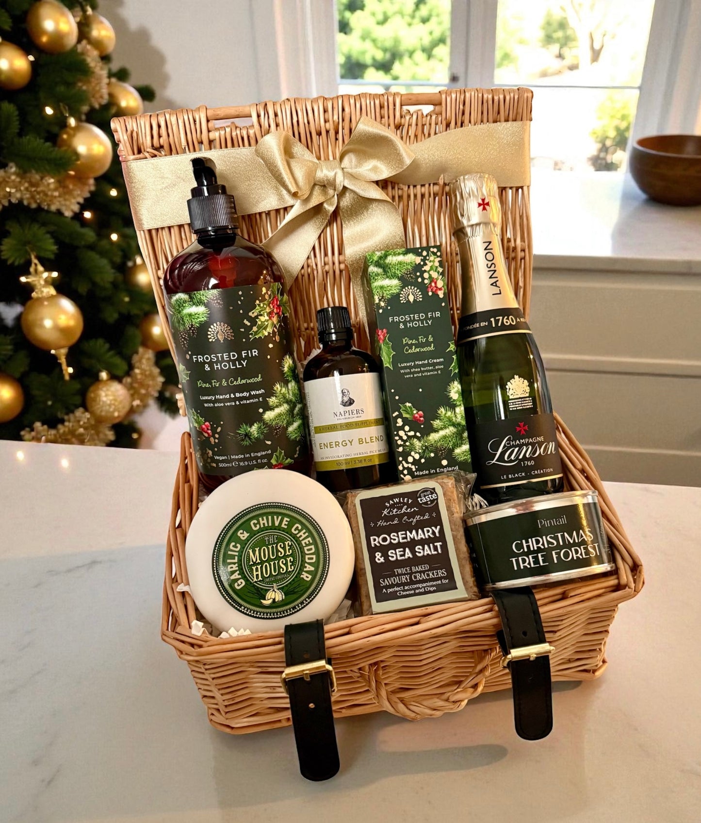 Christmas hamper with Lanson Champagne, Frosted Fir wash & hand cream, cheese, crackers, candle and wellness oil in a ribboned basket.