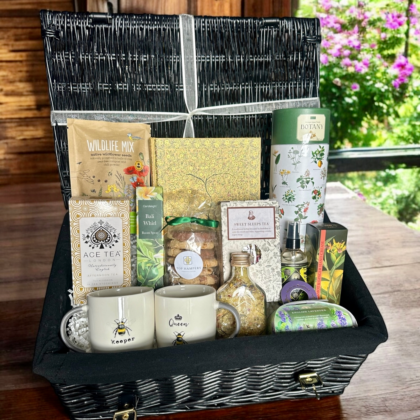Grandparents treat hamper with sweet treats, teas, bath salts, mugs, wildflower seeds, garden puzzle, writing pad, hand cream, soap, and sanitiser.