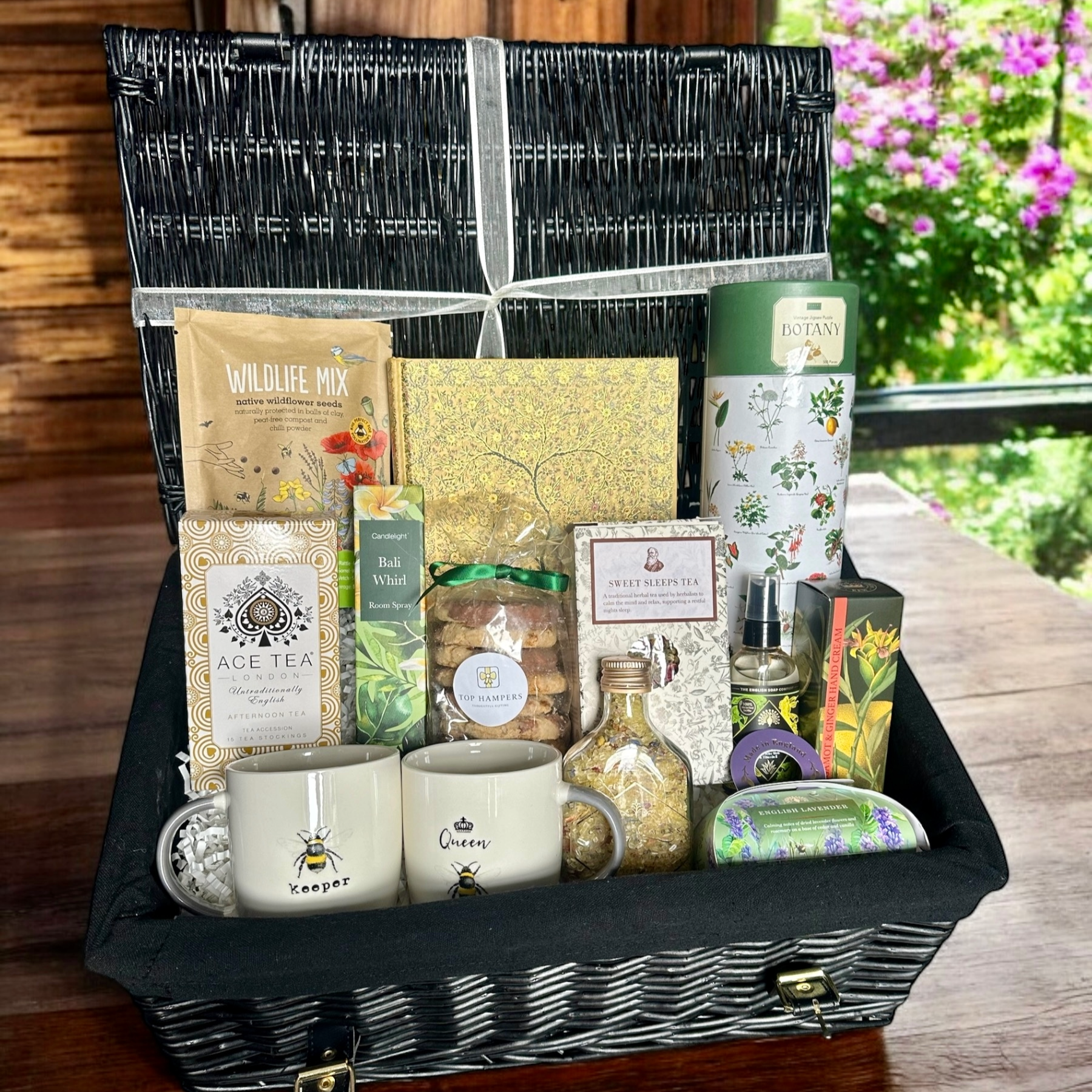 Grandparents treat hamper with sweet treats, teas, bath salts, mugs, wildflower seeds, garden puzzle, writing pad, hand cream, soap, and sanitiser.
