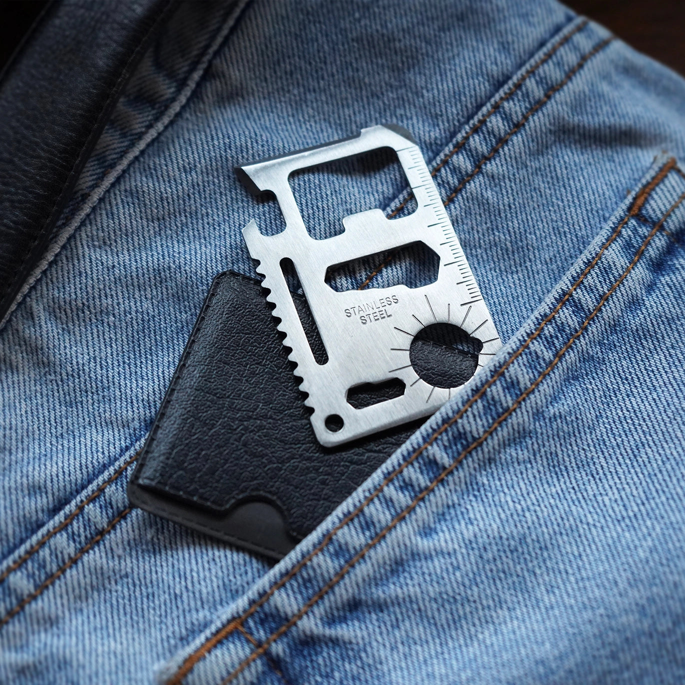 11-in-1 stainless steel wallet multi-tool with protective case, featuring wrenches, bottle opener, saw edge, screwdriver, ruler, and compass guide.