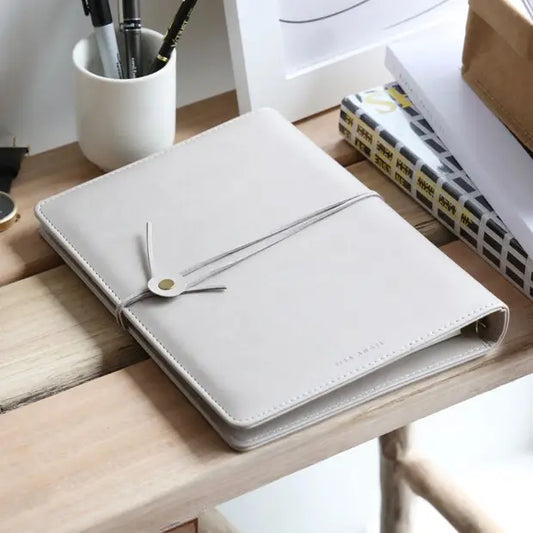 Refillable vegan leather notebook with blank pages and suede cord wrap for secure closure.