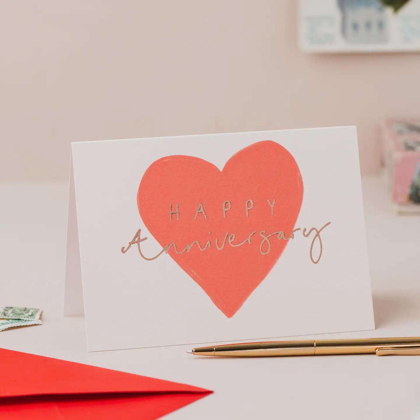 Happy Anniversary greetings card with red heart design and gold foil lettering.