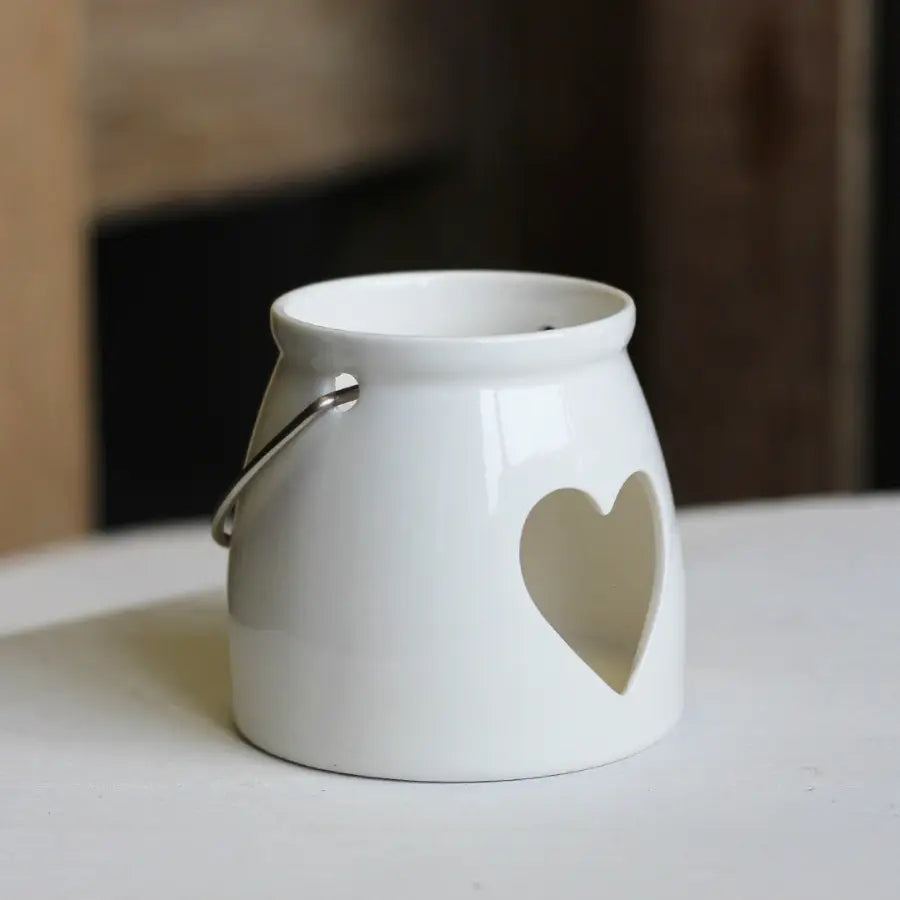 White ceramic lantern with a heart-shaped cutout.