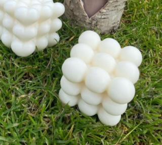 Mini bubble candle by Olga, handmade and scented, on grass.