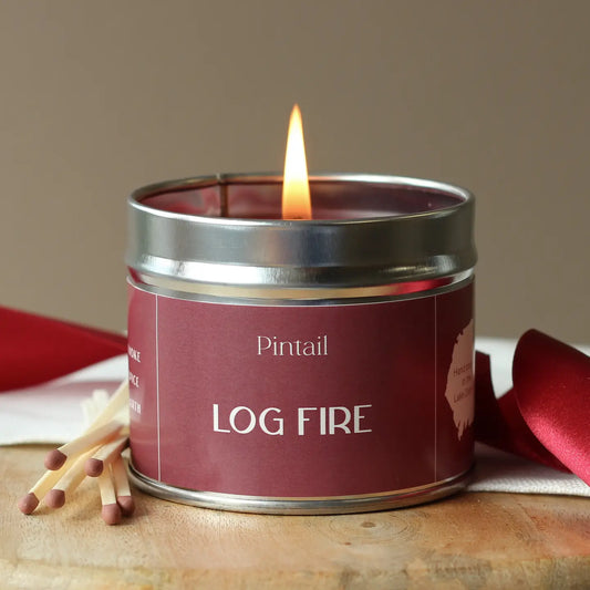Log Fire classic candle tin with warm, rustic packaging, evoking the scent of smoke, cedar, moss, and amber for a cosy fireside atmosphere.