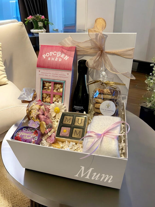 Lovely Mum Hamper with ginger biscuits, chocolates, soap, Prosecco, pink gin, popcorn, sweets, fluffy socks, and daisy candle.