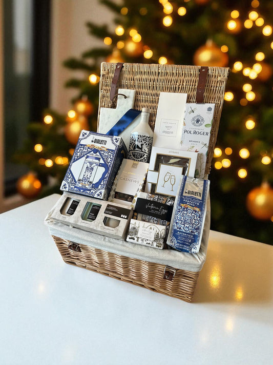 Luxury Christmas Gin & Champagne hamper with Forest Gin, Pol Roger Champagne, Bialetti coffee press, True Grace diffuser, candles, chocolates, and serving board.
