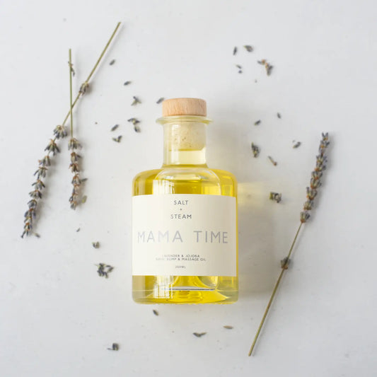 Mama Time Lavender Bath & Bump Oil bottle surrounded by lavender sprigs.