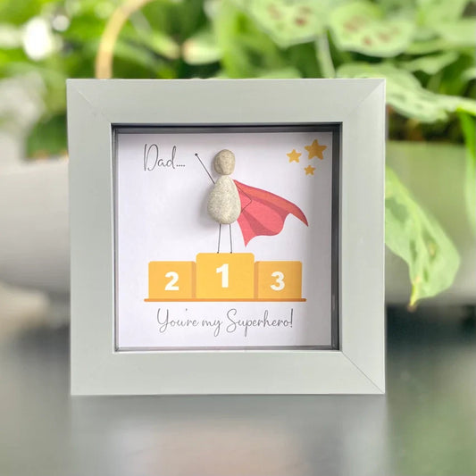 Handmade framed mini pebble artwork gift for dad with superhero theme.