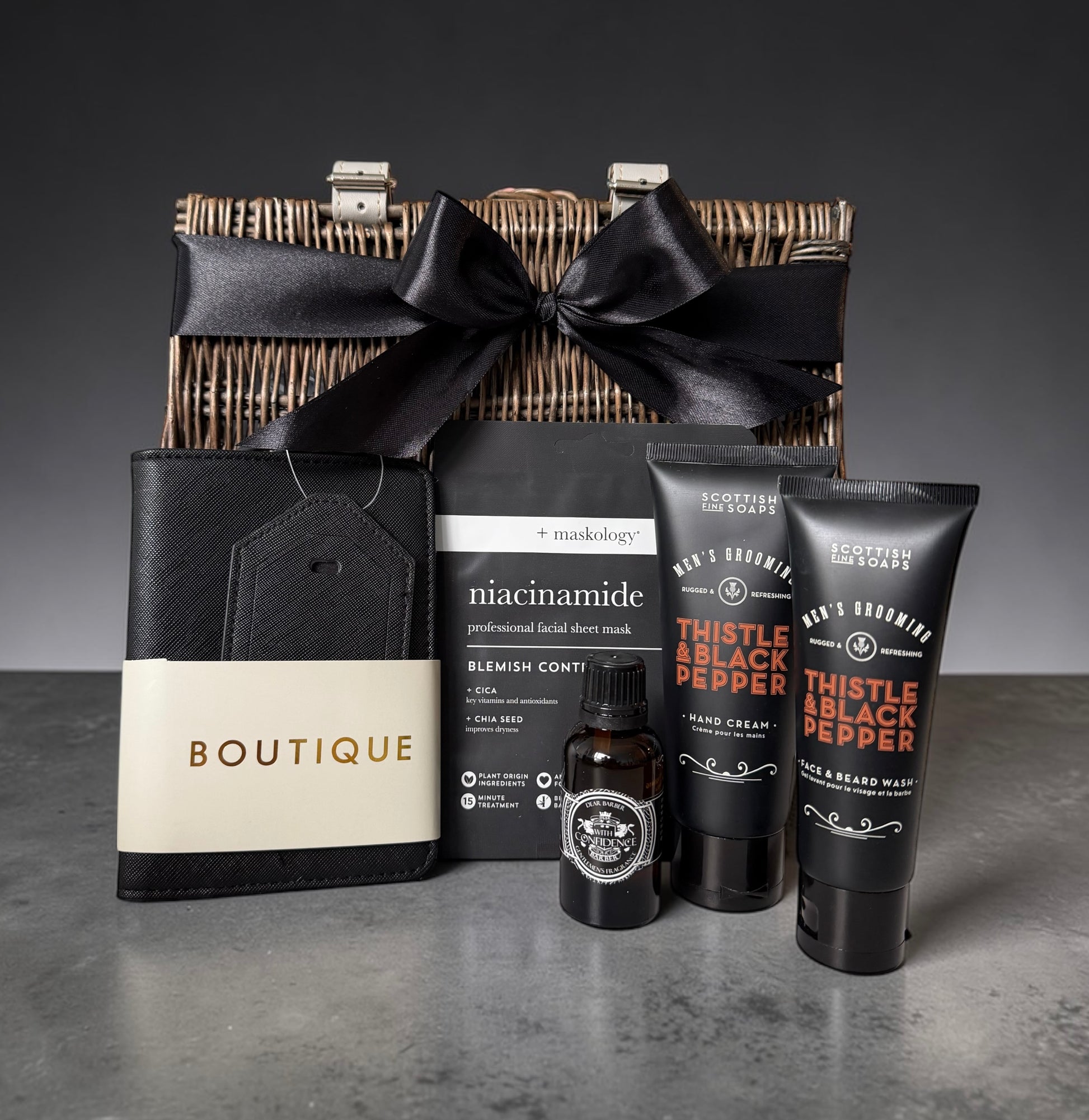 Modern man travel gift set with passport holder, face mask, beard wash, hand cream and travel fragrance.