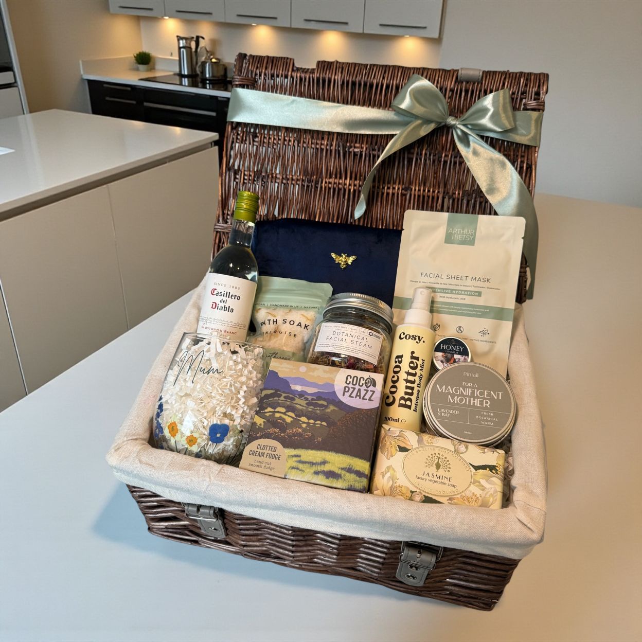 Mum’s pamper gift hamper with facial steam, fudge, makeup bag, lip balm, body mist, hand soap, bath salts, candle and optional white wine.