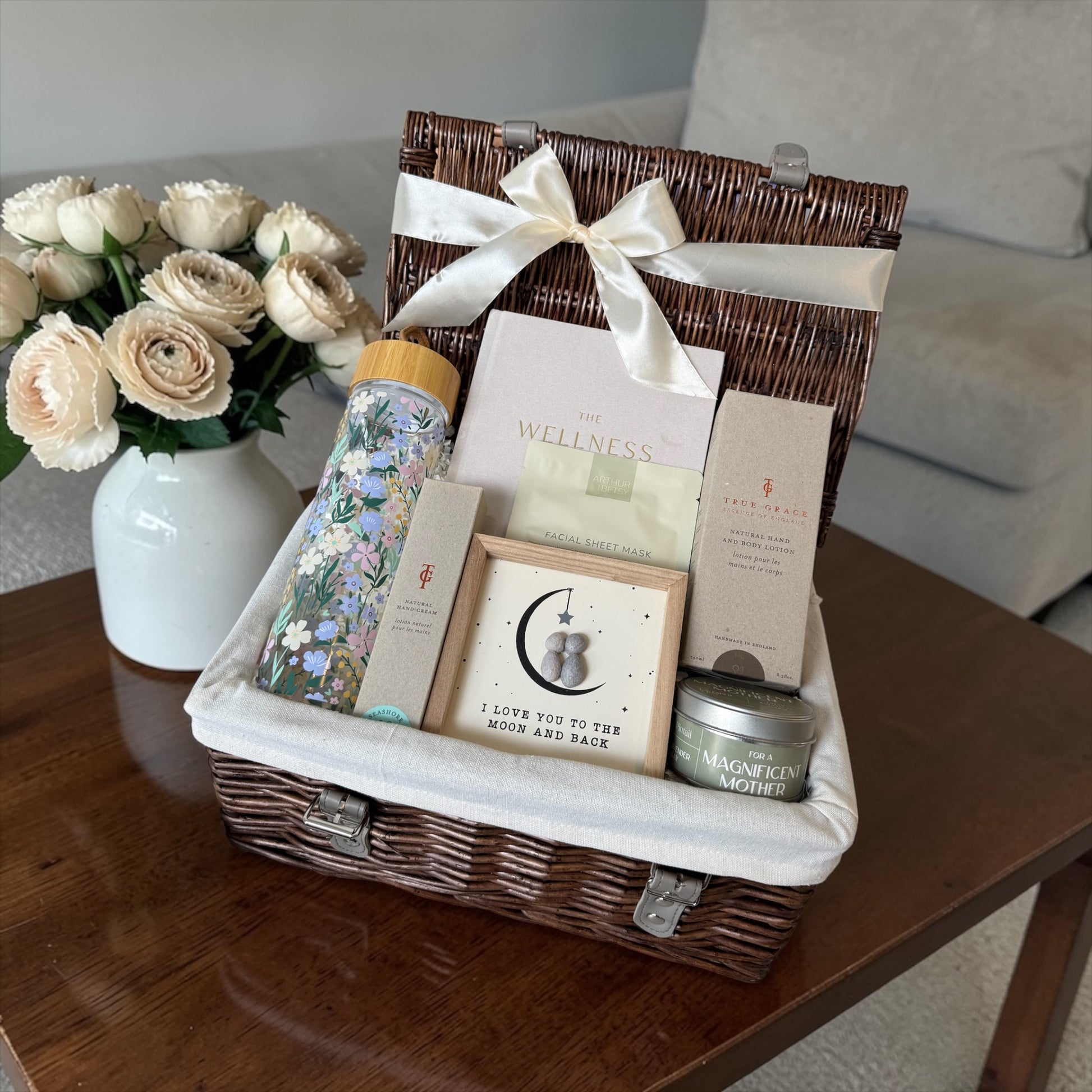 Mum’s Serene Escape gift hamper with wellness journal, floral water bottle, skincare, candle and keepsake pebble artwork.