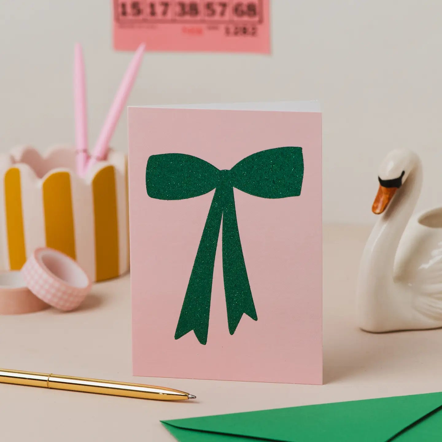 Pink card with green glitter bow design.