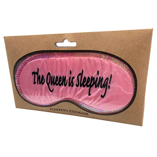 The Queen Is Sleeping pink eye mask with adjustable strap in packaging.