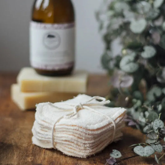 Reusable bamboo makeup pads stacked on a wooden surface, eco-friendly skincare accessory.