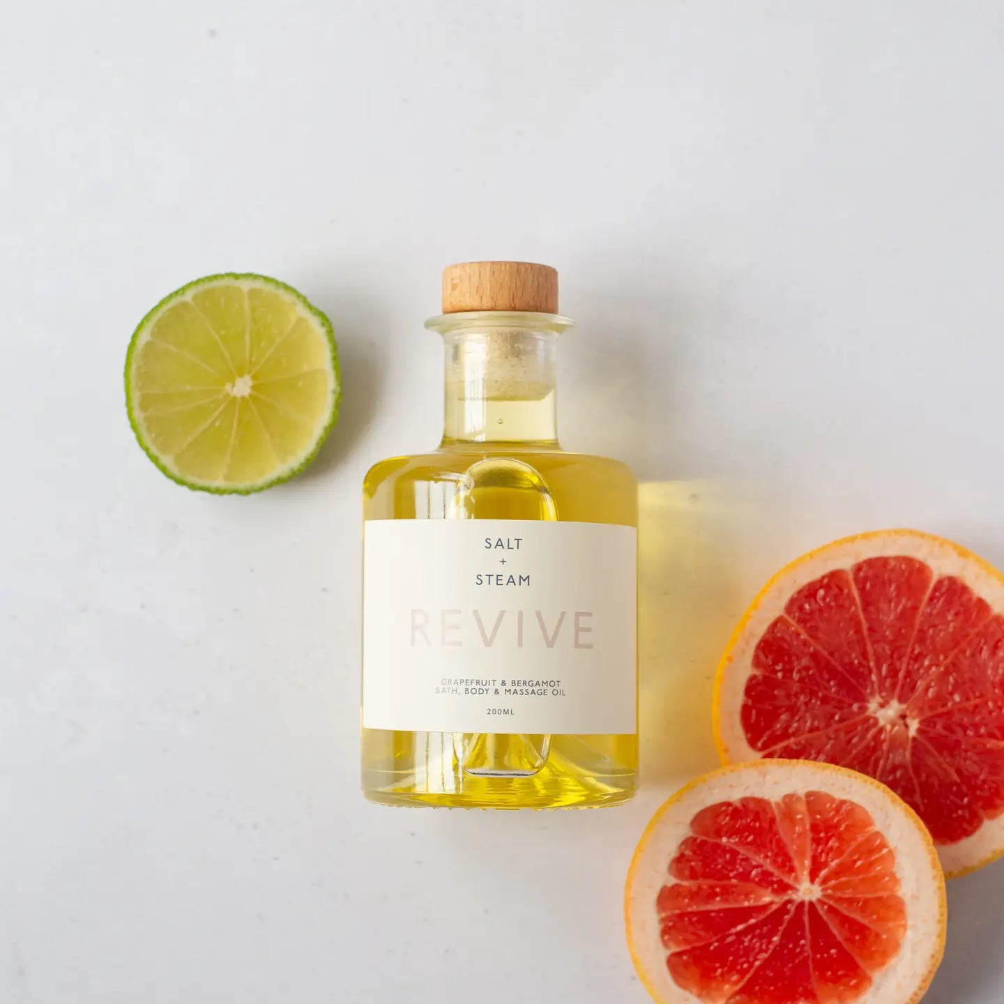 Revive - Grapefruit & Bergamot Bath & Body Oil 100ml with citrus slices, nourishing and scented.