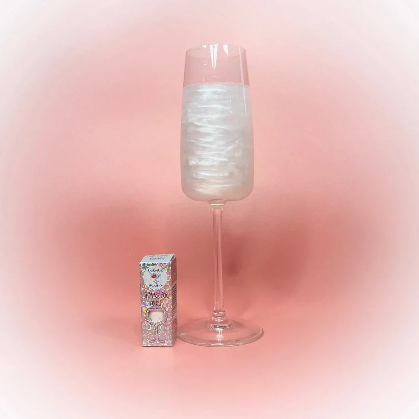 Ice White Drink Shimmer Powder next to a sparkling beverage in a glass.