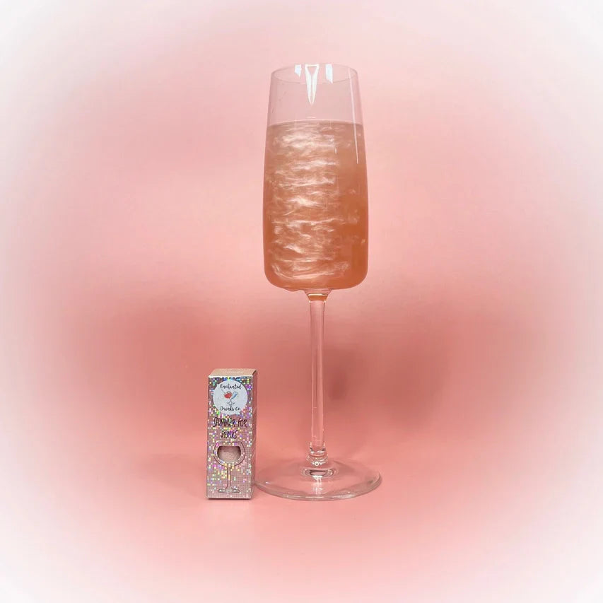 Rose Gold Drink Shimmer Powder beside a sparkling beverage.