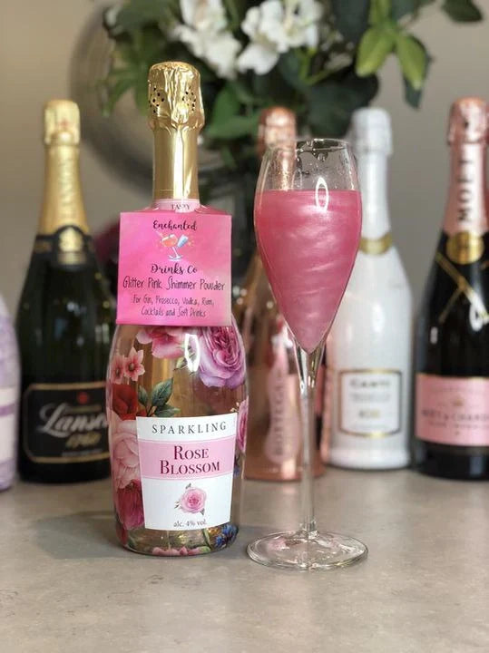 Glitter Pink Shimmer Powder in drink next to Rose Blossom bottle.