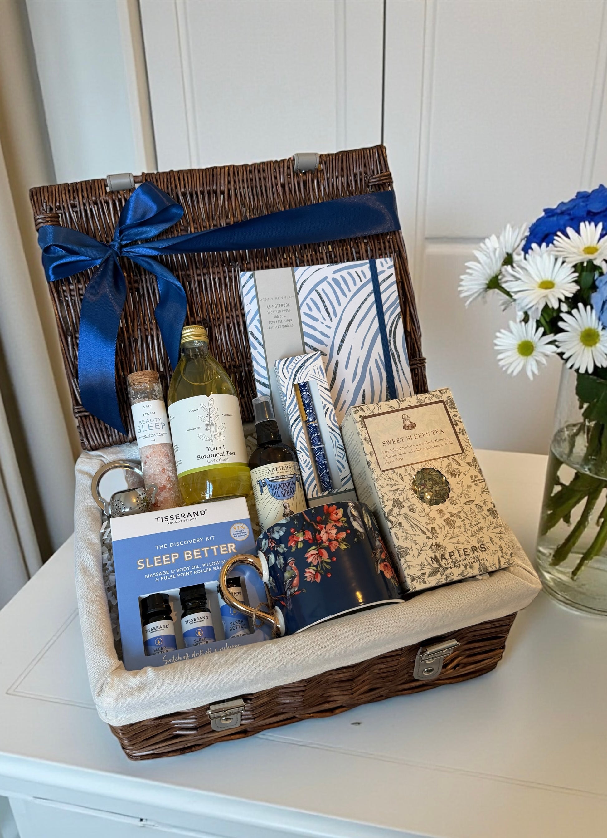 Sleep better gift hamper with various sleep wellness items including botanical tea, mug and bath salts