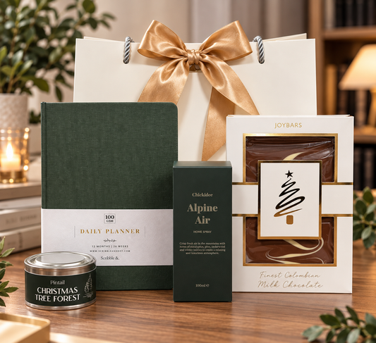 Festive Focus Gift Bag featuring a green daily planner, Alpine Air home spray, Christmas Tree Forest candle and Joybars milk chocolate with gold ribbon.
