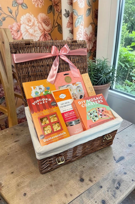 The Artistic Craft Gift Hamper brings embroidery and mosaic kits, coloured pencils, a notebook, candle, popcorn and fudge for creative minds.