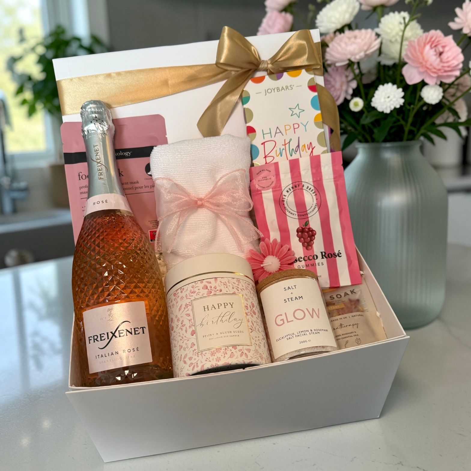 Luxury birthday gift hamper with Freixenet rosé, glow salt steam, candle, foot mask and sweet treats