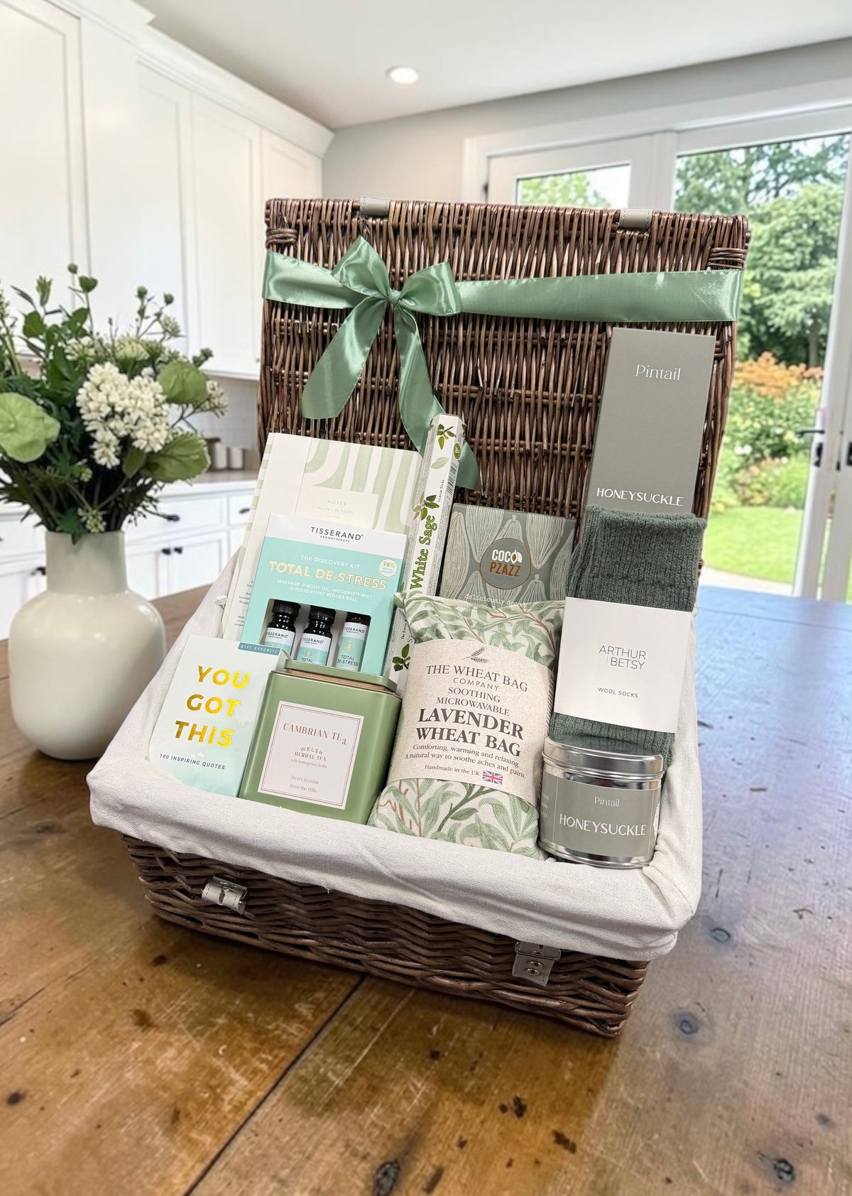 The Care Package Hamper with a de-stress discovery kit, wheat bag, wool socks and a choice of Get Well Soon chocolate or dusted truffles.
