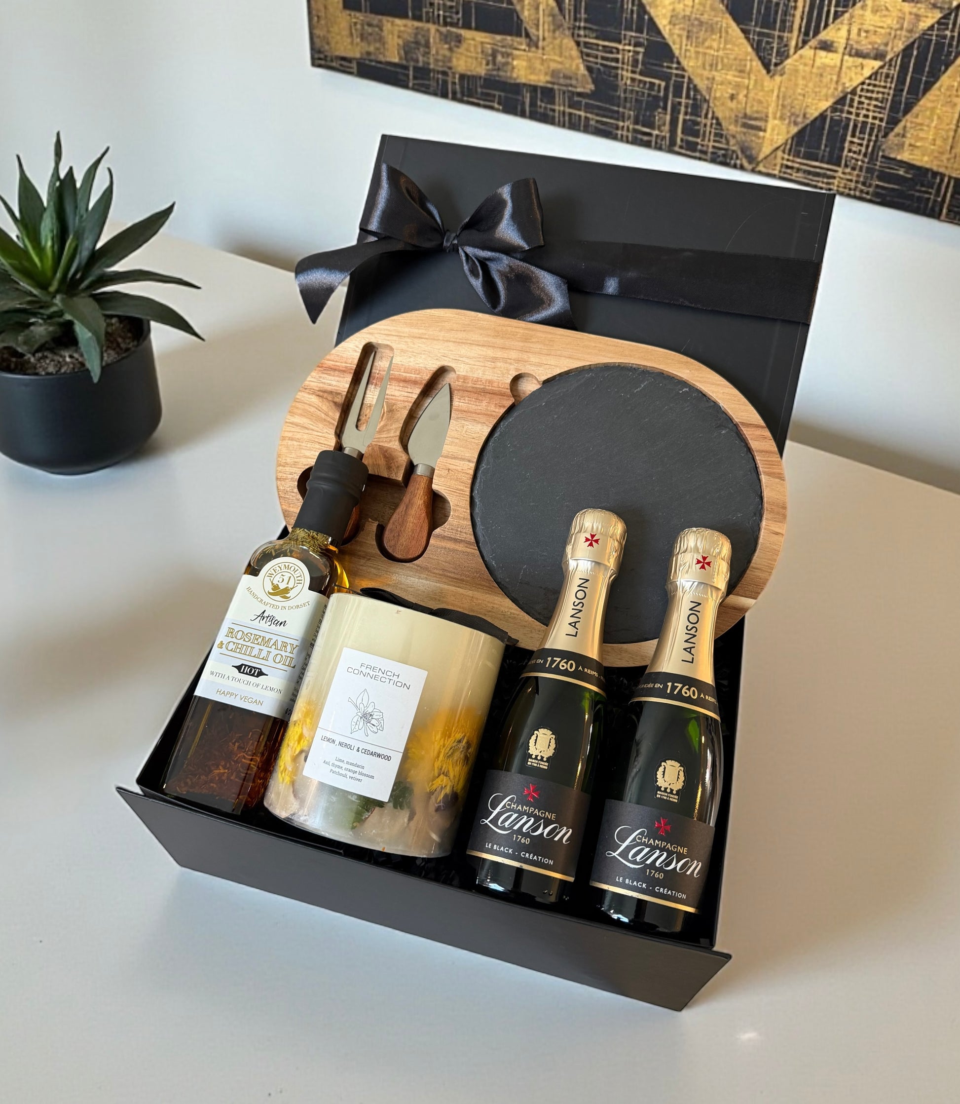 Corporate gift hamper with cheese board and knives, infused oil, luxury candle and choice of Birra Moretti beers or Lanson Champagne.