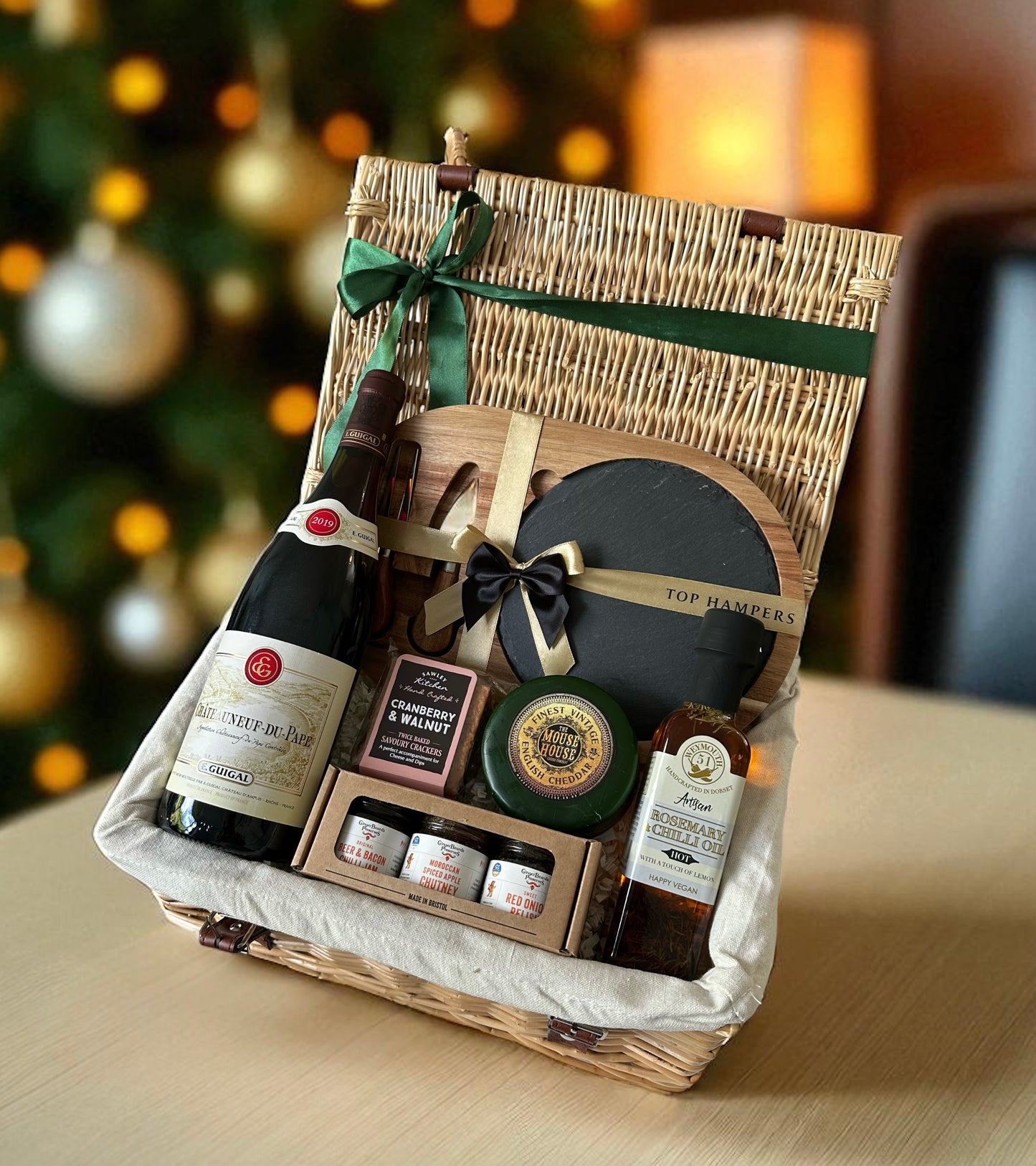 Christmas Cracker & Cheese Hamper featuring Château Neuf du Pape wine, vintage cheddar truckle, cranberry & walnut crackers, miniature preserves, rosemary & chilli oil, and slate & wood cheese board.