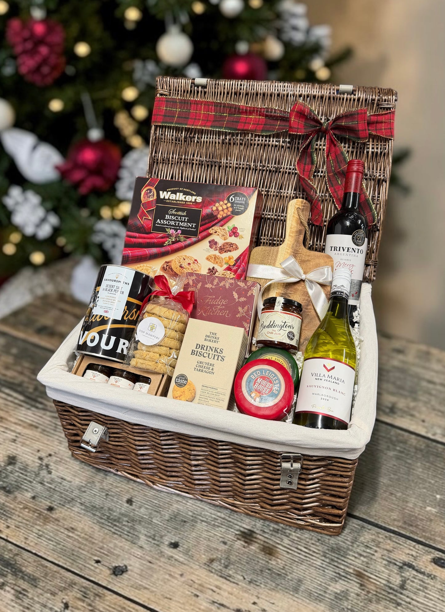 The Christmas Wine, Cheese and Nibbles Hamper with red and white wine, cheese, chilli jam, biscuits, fudge and crisps. A generous festive gift for anyone.