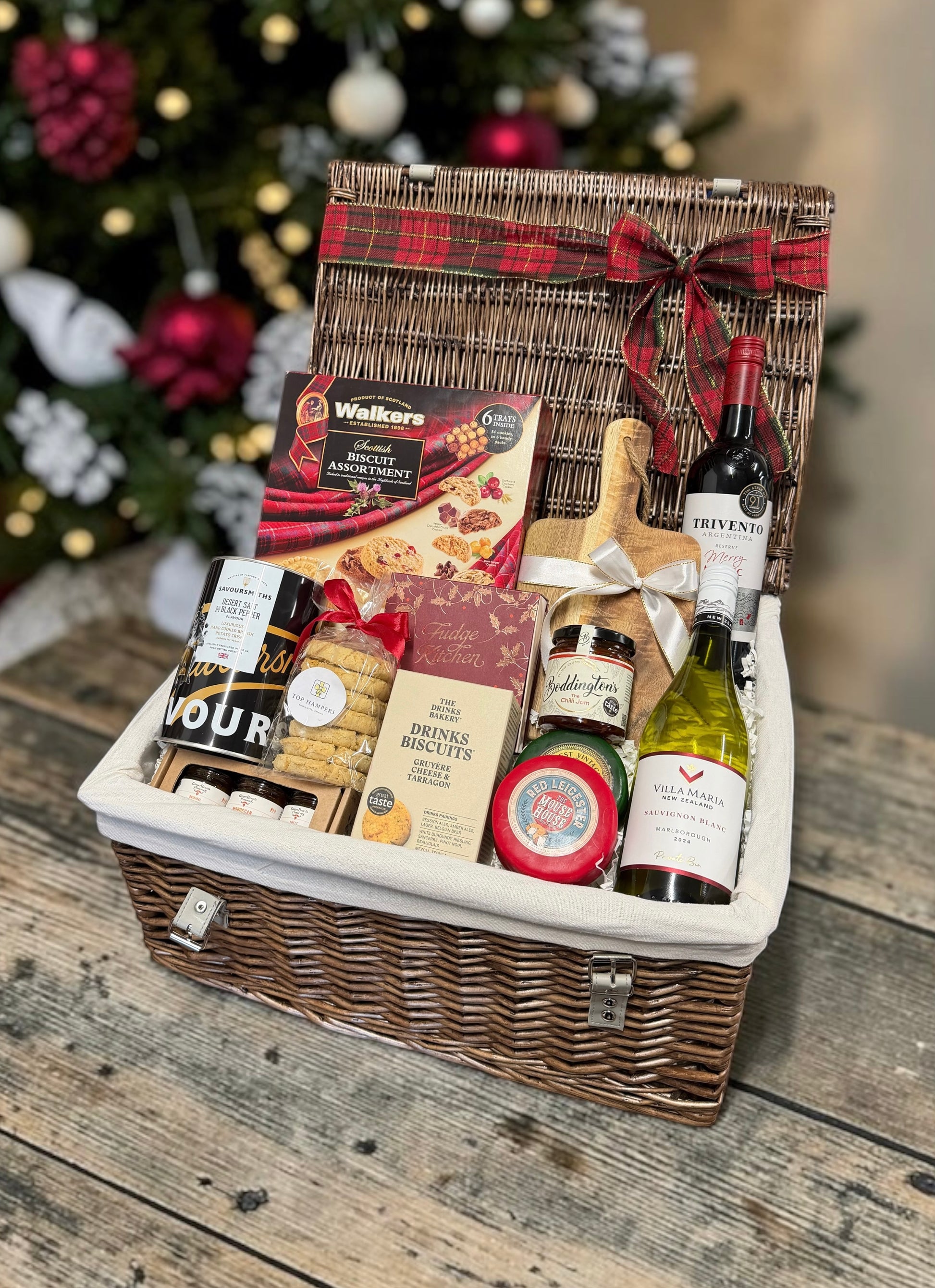 The Christmas Wine, Cheese and Nibbles Hamper with red and white wine, cheese, chilli jam, biscuits, fudge and crisps. A generous festive gift for anyone.
