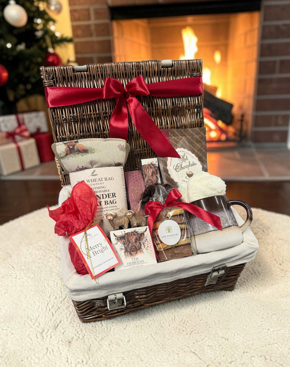 The Highland Cow Christmas Comforts Hamper with a lavender wheat bag, soap, hot chocolate, a cocoa mug, fudge and more. A cosy festive gift with character.