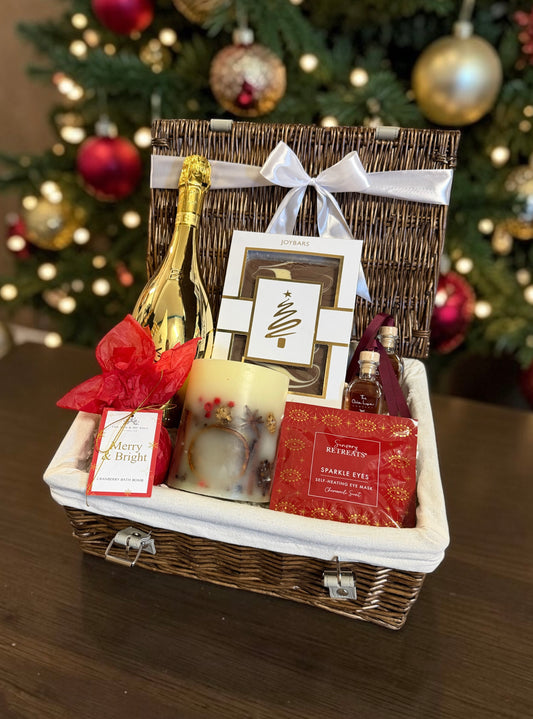 The Merry & Bright Hamper with a bottle of Bottega Prosecco, Mini Christmas liqueurs, candle, chocolate, bath bomb and eye mask.