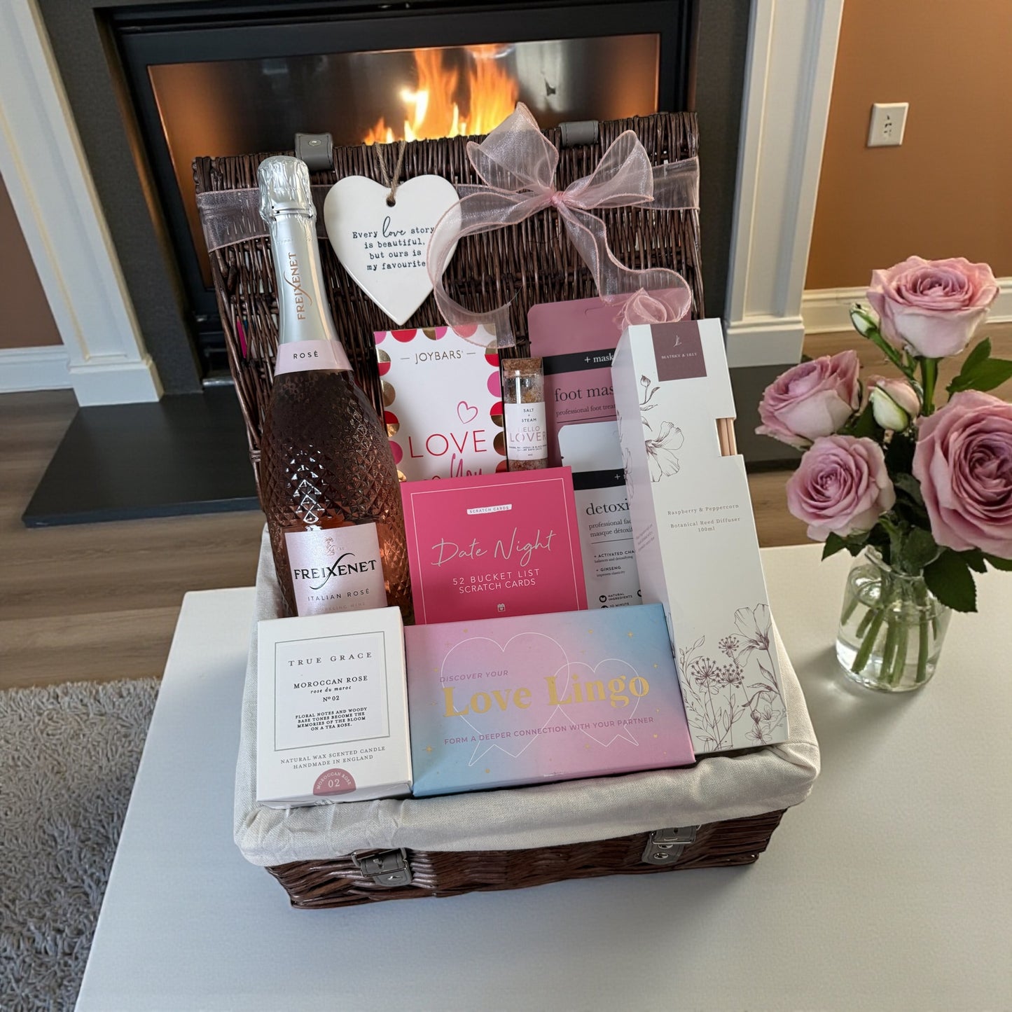 Romantic luxury gift hamper with rosé fizz, candles, self-care treats and love-themed gifts