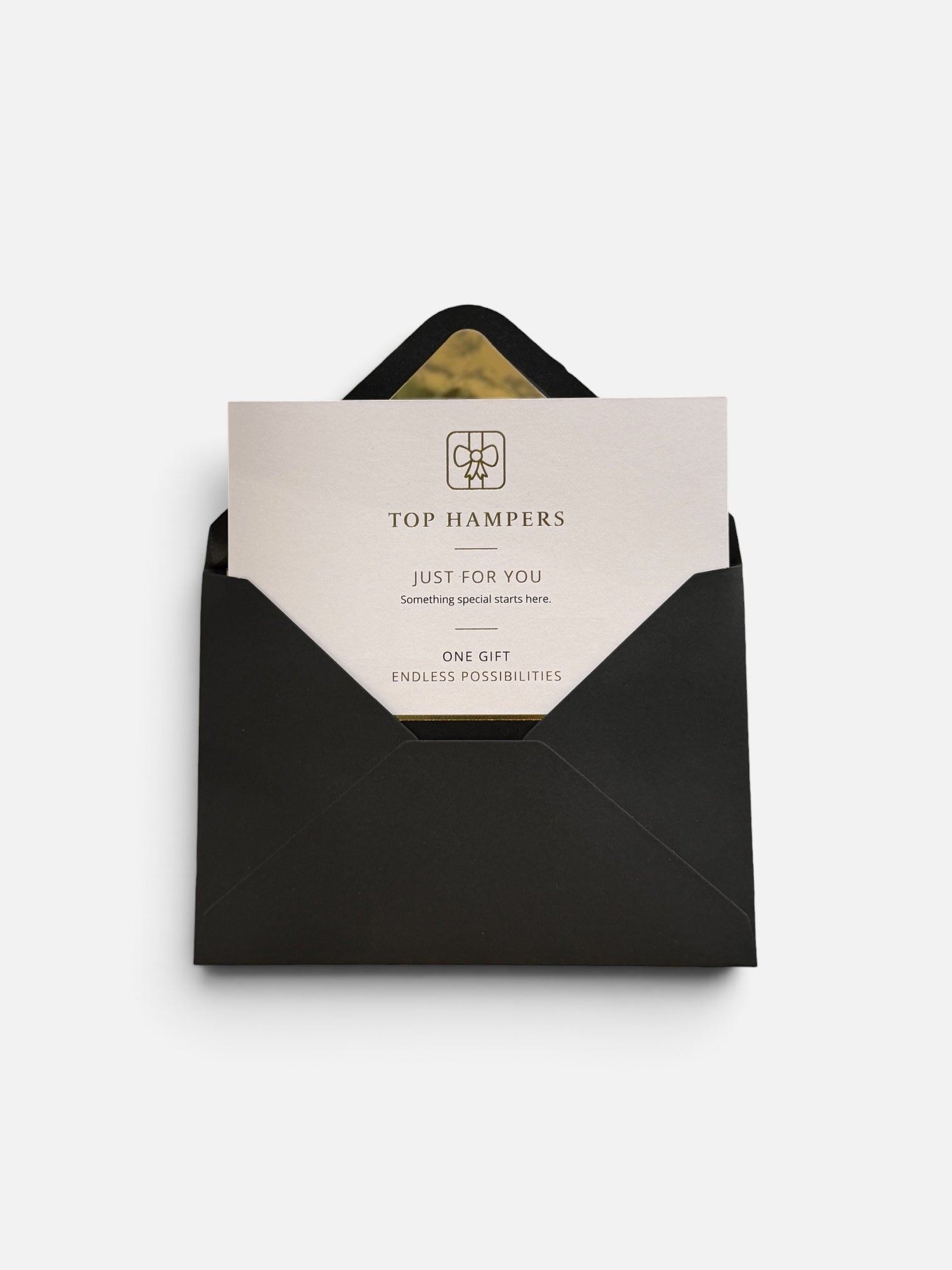 A black envelope with a white gift card partially pulled out, featuring the TOP HAMPERS logo and the words 'JUST FOR YOU' and 'ONE GIFT ENDLESS POSSIBILITIES' on a clean white background.