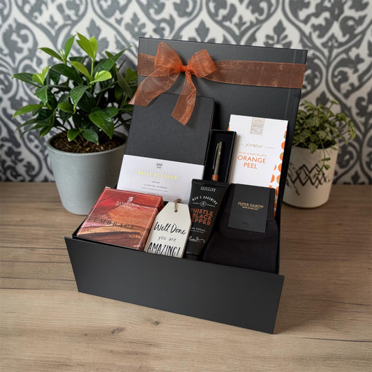 Gift hamper for him with planner, pen, orange peel chocolate bites, bath soak, luxury socks, hand cream and well done hanging sign.