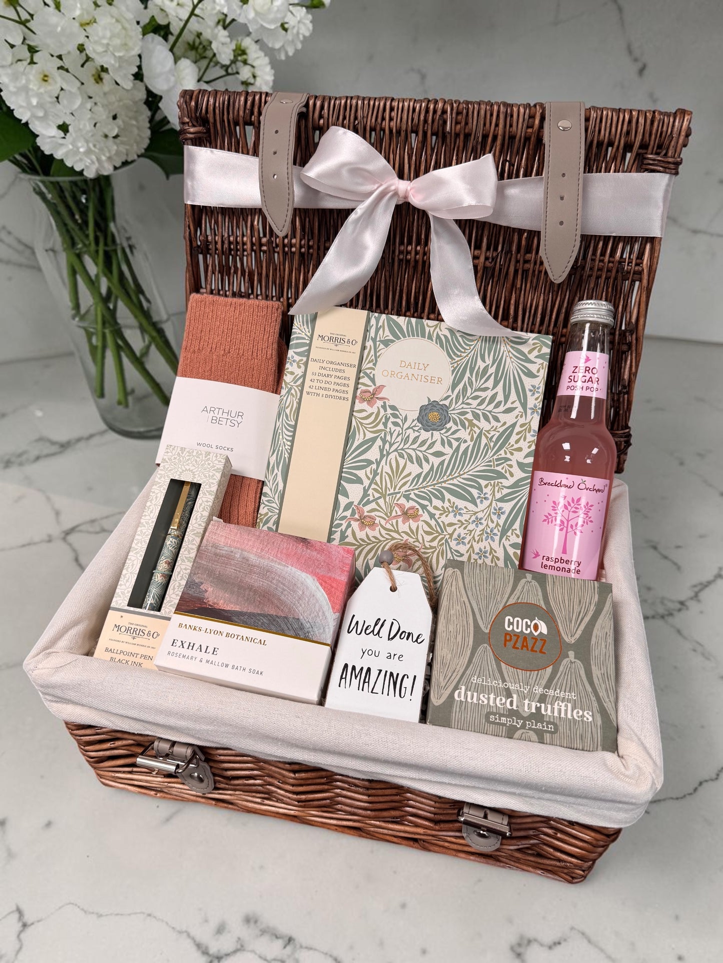 Well Done Gift for Her hamper with William Morris organiser pad, matching pen, Arthur Betsy socks, Exhale bath soak, sweet treats and celebratory drink.