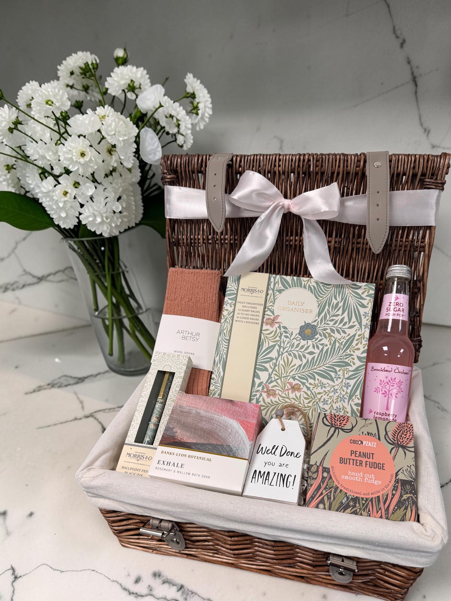Well Done Gift for Her hamper with William Morris organiser pad, matching pen, Arthur Betsy socks, Exhale bath soak, sweet treats and celebratory drink.