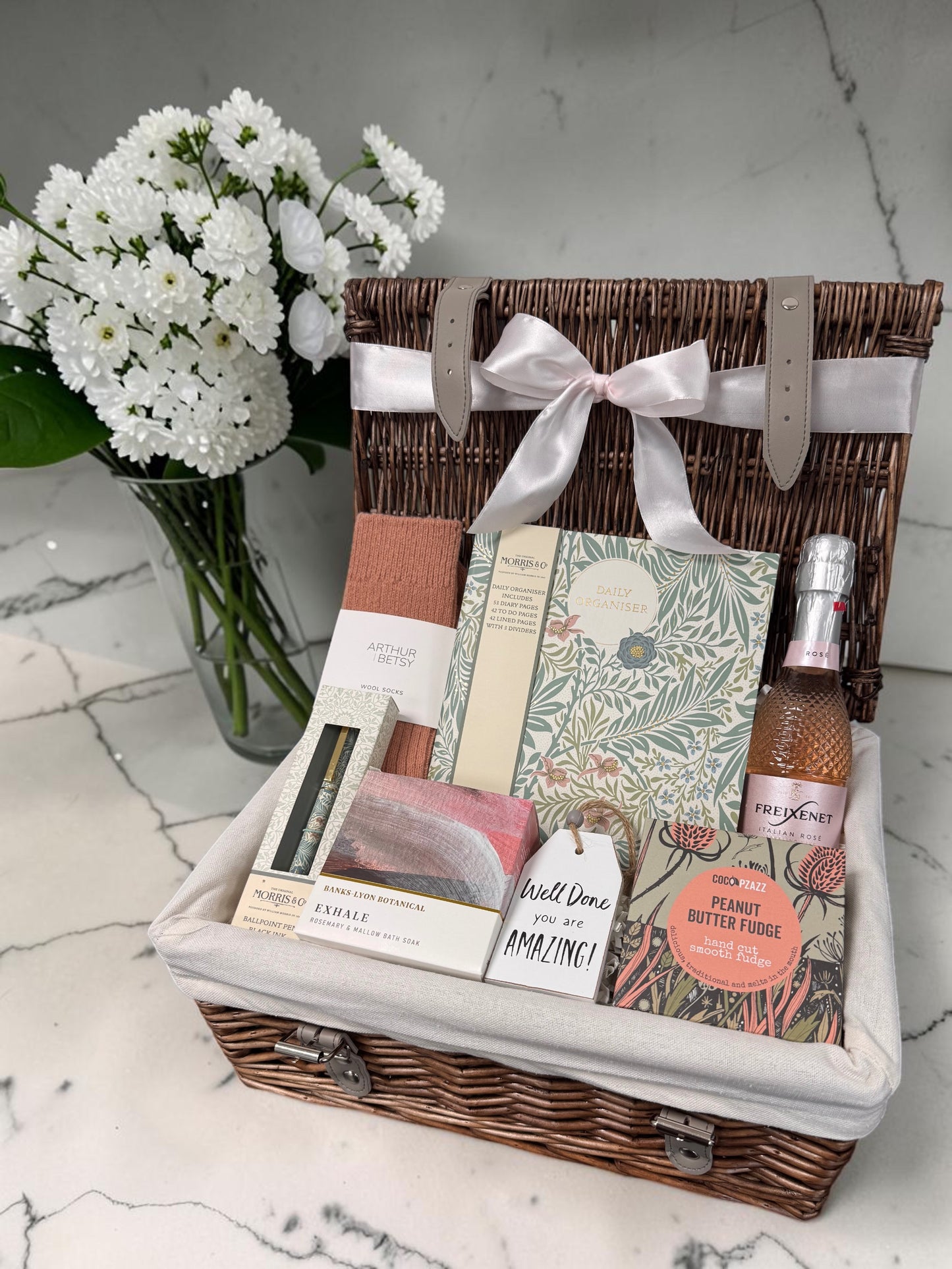 Well Done Gift for Her hamper with William Morris organiser pad, matching pen, Arthur Betsy socks, Exhale bath soak, sweet treats and celebratory drink.
