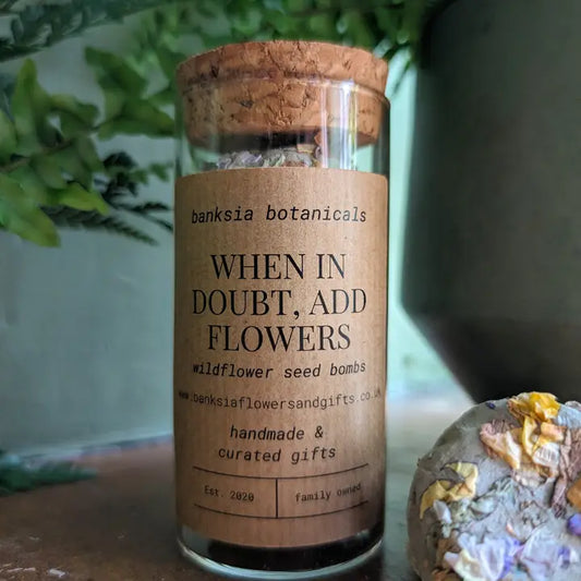 Wildflower seed bombs in a corked jar labeled "When in Doubt, Add Flowers."