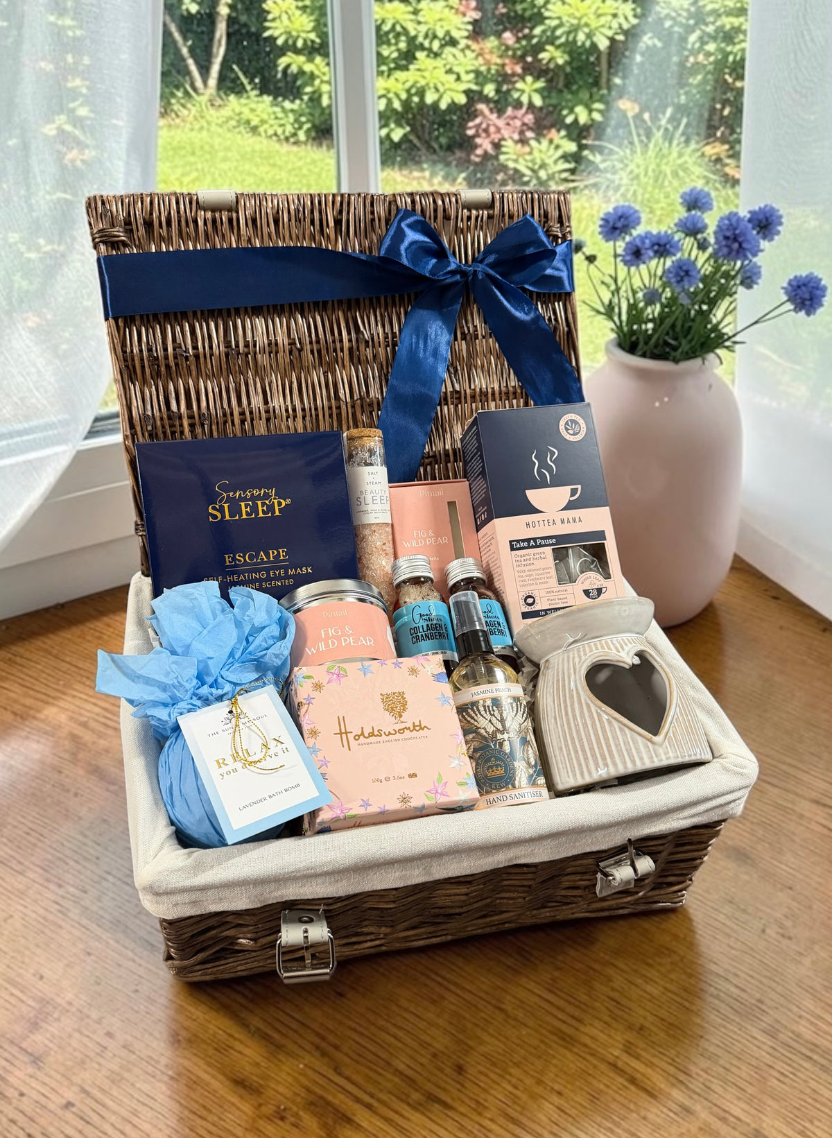 Women's Wellness & Relaxation Hamper with a menopause support tea, self-heating eye mask, bath salts and chocolates, with an optional bottle of rosé or fizz.