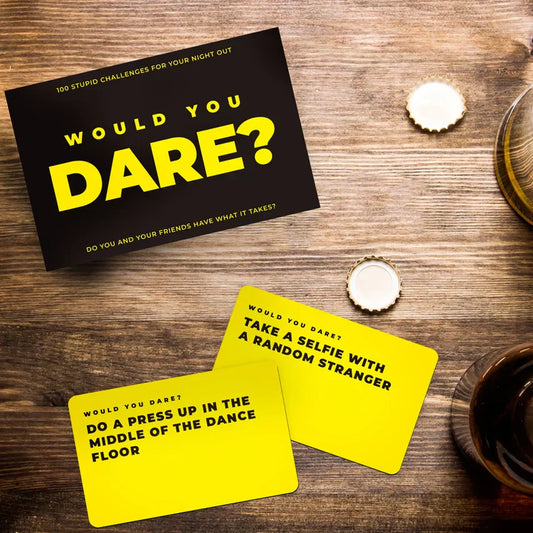 Male "Would You Dare?" Challenge Card Game on wooden table, featuring daring challenges for fun stag dos and lads' nights.