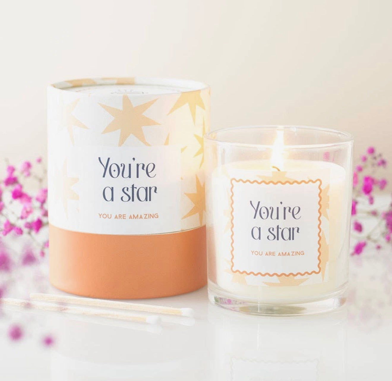 Candle with 'You're a star' message and packaging on a light background
