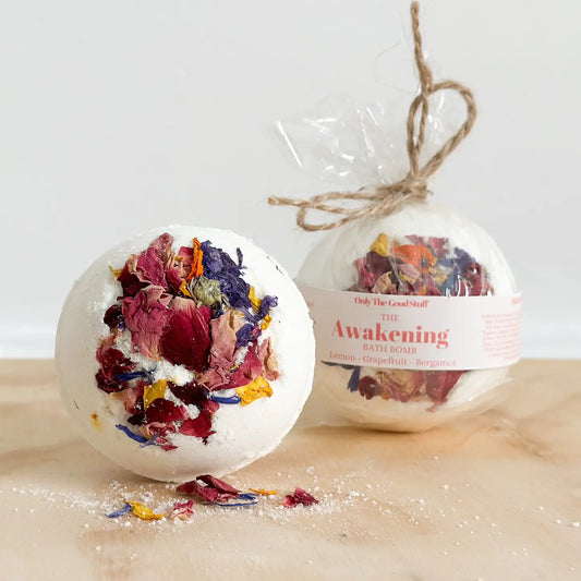 The Awakening Bath Bomb with dried floral accents on wooden surface.