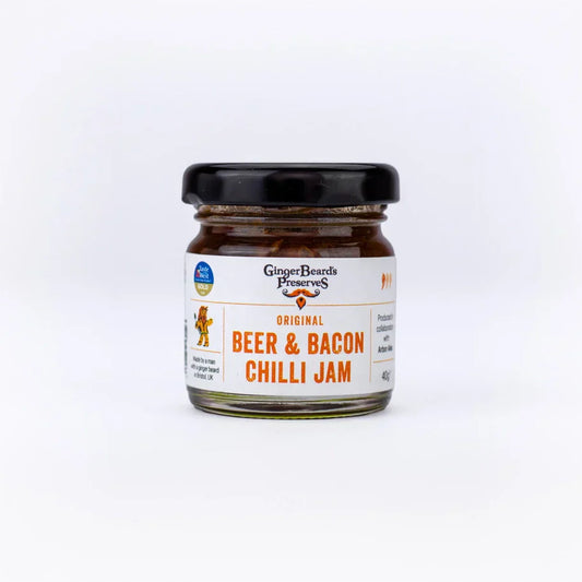 Miniature jar of Beer & Bacon Chilli Jam, perfect for gourmet sandwiches and cheese platters.