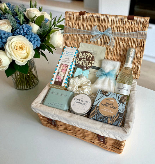 Birthday gift for her with prosecco, a candle, fudge and cosy socks.