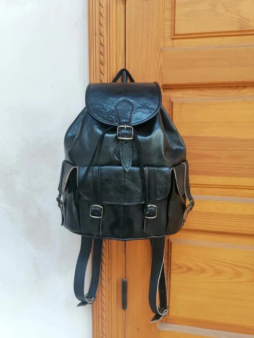 Black handmade premium Moroccan leather backpack hanging, offering style and durability for travel and daily use.