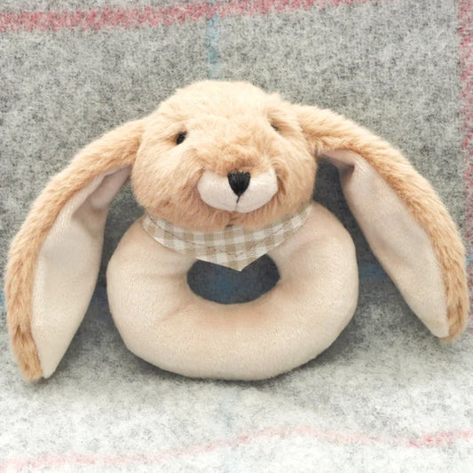 Cute brown bunny soft baby rattle toy on a patterned blanket.