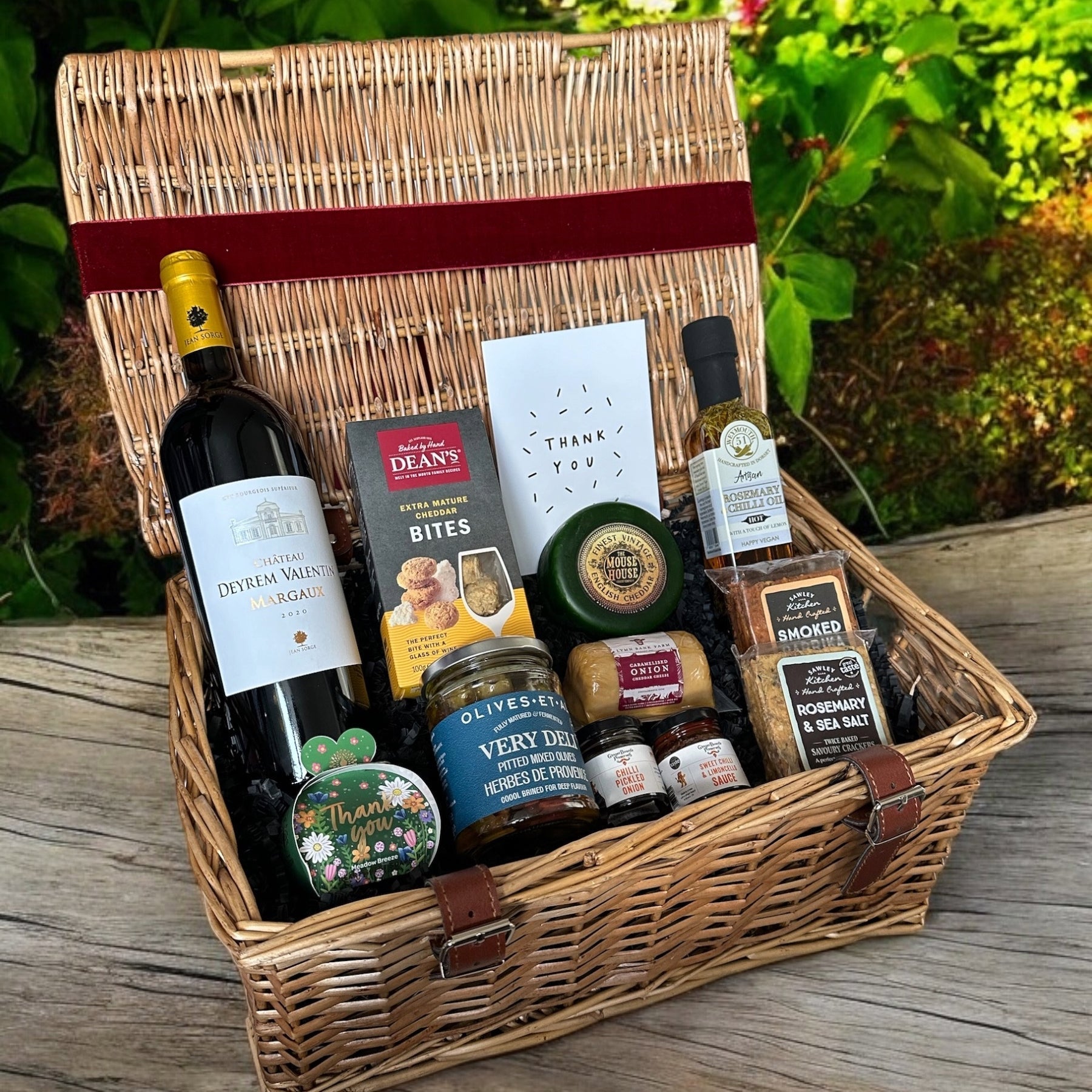 Thank you Hamper filled with gourmet treats and wine in a wicker basket.
